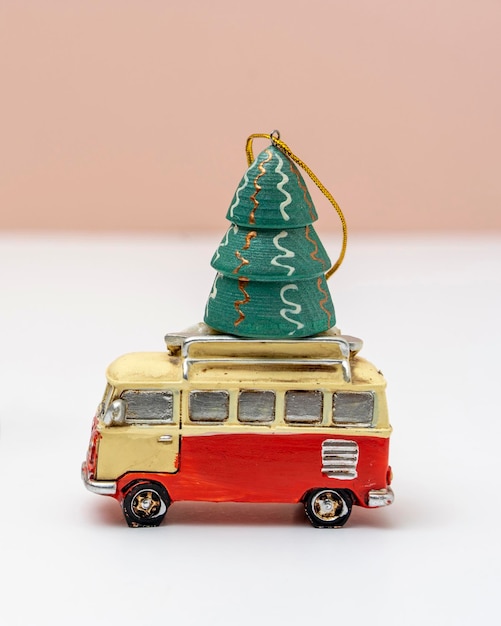 La voiture jouet transporte un sapin de Noël jouet, un sapin de Noël et un minibus