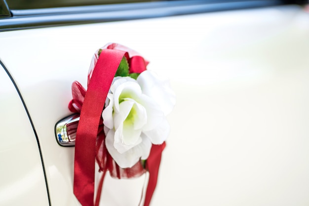 Voiture de mariage blanche décorée de fleurs fraîches. Décorations de mariage.