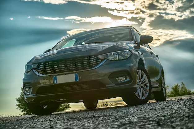 Voiture moderne prise d'en bas avec grand angle derrière avec coucher de soleil et une belle lumière qui contraste.