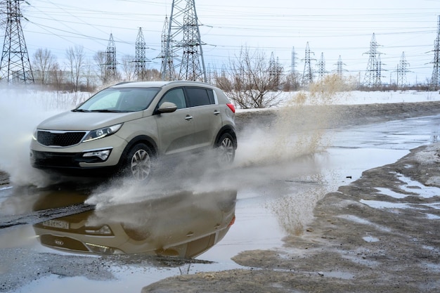 Voiture de mouvement grande flaque d'eau pulvérisée par les roues