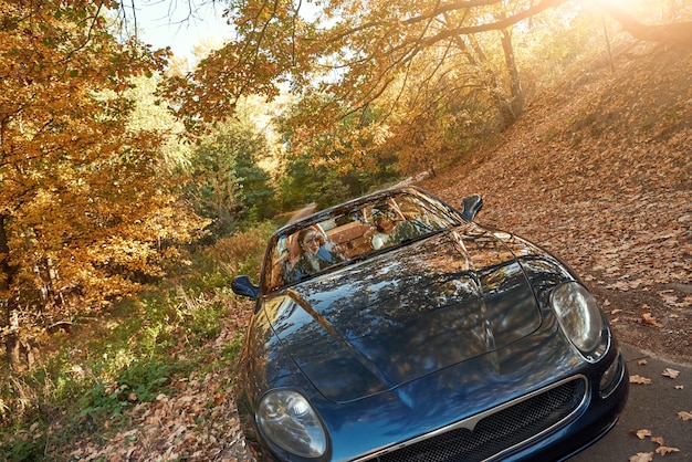 Une voiture noire sans toit roulant rapidement sur l'asphalte avec un beau lever de soleil