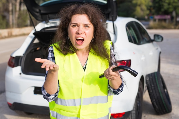 Photo une voiture en panne. les femmes insistent sur le fait que la voiture a en panne une personne.