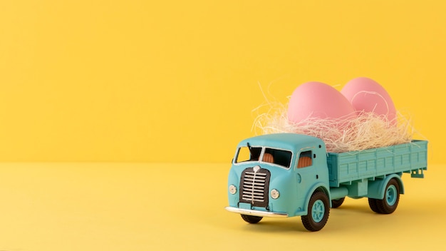 Voiture de Pâques bleue avec des oeufs roses