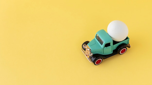 Voiture de pâques verte avec angle élevé d'oeuf blanc