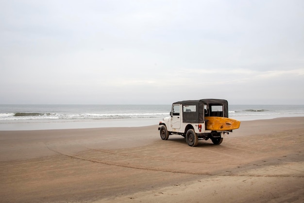 Voiture avec planche de surf sur la plage