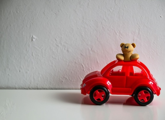 Photo voiture en plastique sur mur blanc avec ours