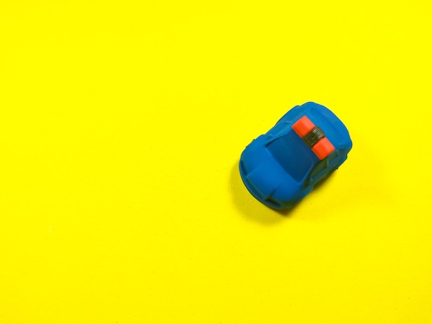 Voiture de police jouet bleu sur fond jaune avec espace de copie