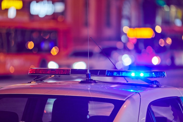 La Voiture De Police S'allume Dans La Rue De La Ville De Nuit. Lumières Rouges Et Bleues. Accident De La Circulation. Patrouilles Du Soir