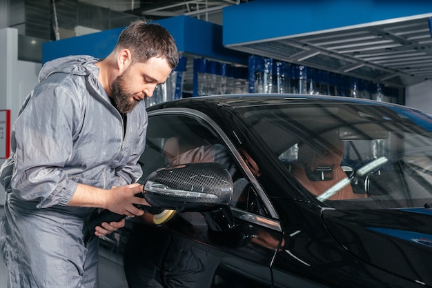 Voiture de polissage des travailleurs avec broyeur spécial et cire des rayures à la station-service