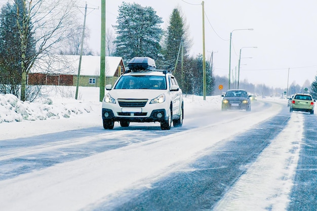 Voiture avec porte-bagages de toit sur la route en hiver Rovaniemi, Laponie, Finlande