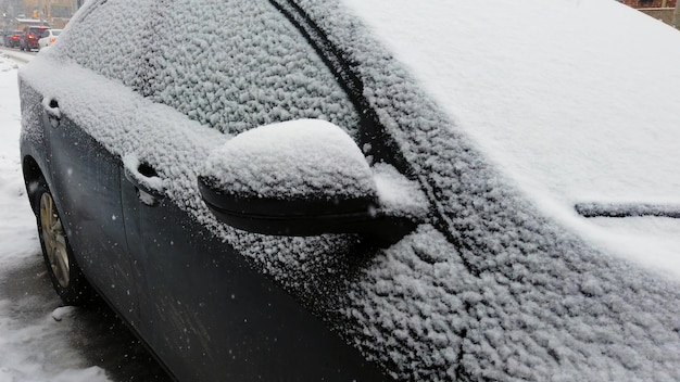 Une voiture recouverte d'une couche de neige pendant une tempête hivernale