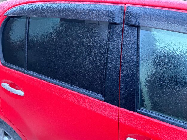 Voiture recouverte de glace en gros plan La glace scintillante a tout recouvert après le cyclone de la tempête de verglas et la pluie verglaçante Terrible beauté de la nature concept Heure d'hiver Mise au point sélective