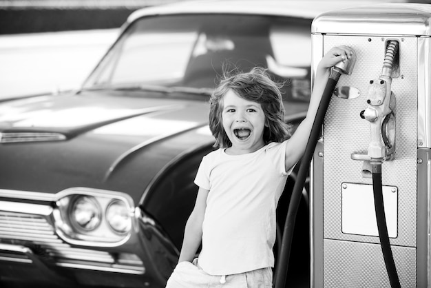 Voiture rétro de ravitaillement pour enfants à la station-service faire le plein avec de l'essence essence carburant de remplissage de la pompe à essence non