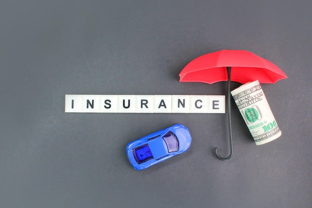 Photo une voiture rouge et un parapluie rouge à côté d'un billet de cent dollars.