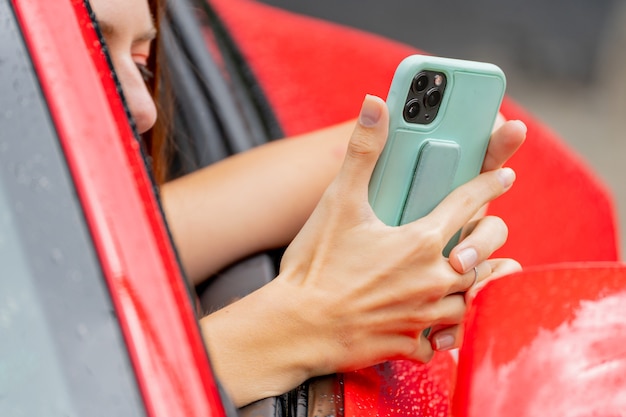 Voiture rouge et téléphone. Appels au téléphone. Style de jeunesse à la mode moderne.