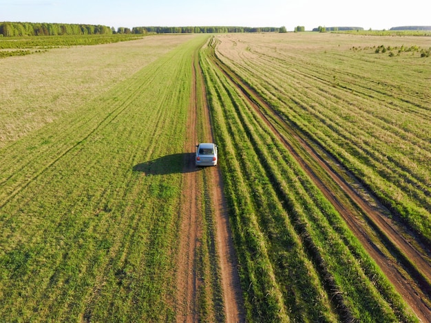 Voiture sur la route sur un champ vert photo du drone