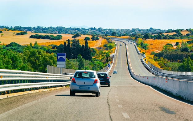 Voiture sur la route à Costa Smeralda en île de Sardaigne en Italie l'été. Transport roulant sur l'autoroute de l'Europe. Vue sur autoroute. Province d'Olbie. Technique mixte.