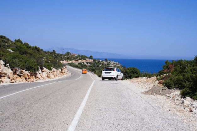 Voiture seule sur une route ensoleillée au bord de la mer