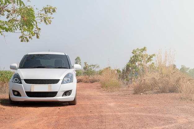 Voiture de sport blanche sur chemin de terre