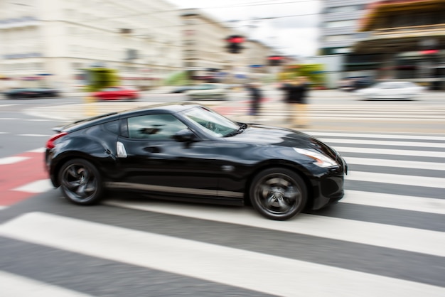 La voiture de sport noir a brouillé sur le mouvement de la vitesse.