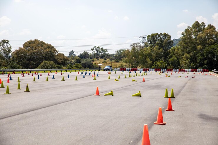 Une voiture de sport se tient sur le parking avec des cônes en arrière-plan