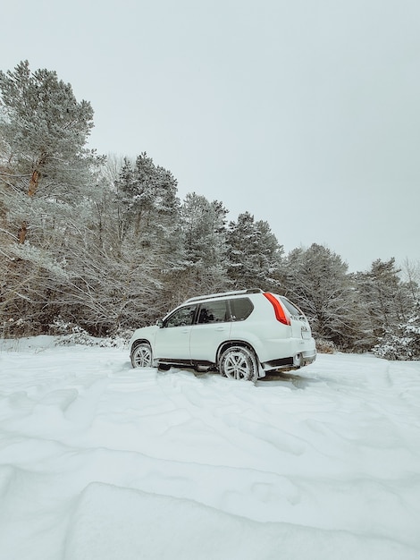 Voiture SUV au milieu de l'espace de copie de forêt enneigée