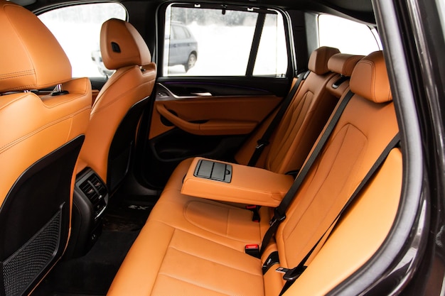 Voiture SUV moderne à l'intérieur des sièges passagers arrière en cuir noir dans une voiture de luxe moderne avec accoudoir ouvert Sièges en cuir confortables