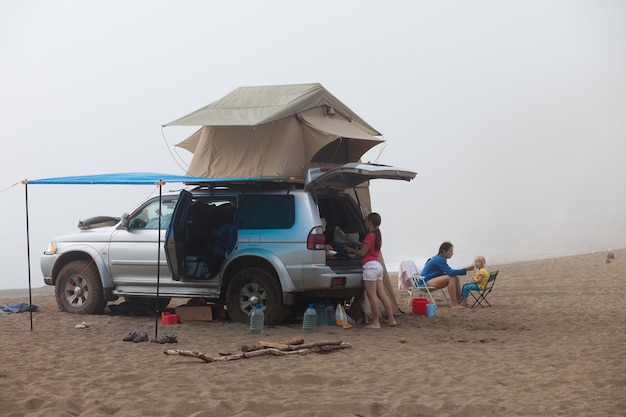 Voiture avec tente de toit au bord de la mer