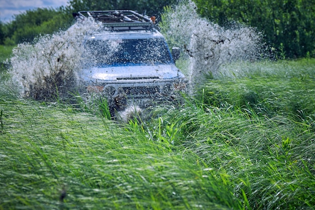 Une voiture tout-terrain s'est écrasée dans une flaque d'eau et a soulevé des éclaboussures de boue