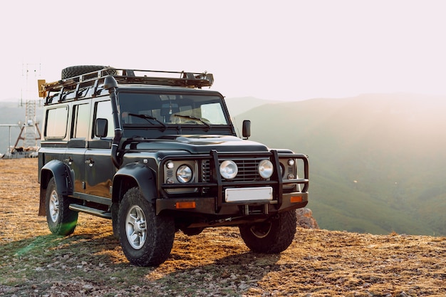 Voiture tout-terrain vert foncé dans les montagnes