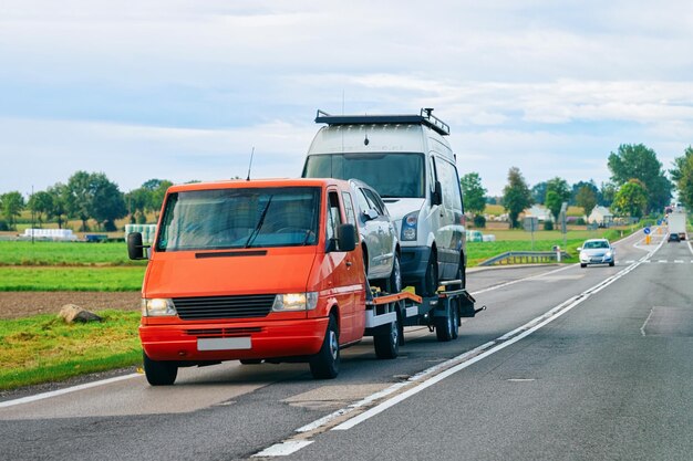 Photo voiture transportant une remorque avec des mini-fourgonnettes sur la route goudronnée de slovénie.