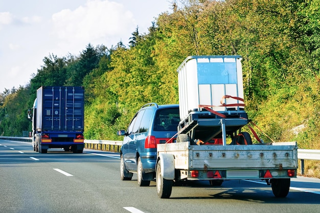 Voiture transportant une remorque sur la route goudronnée de Slovénie.