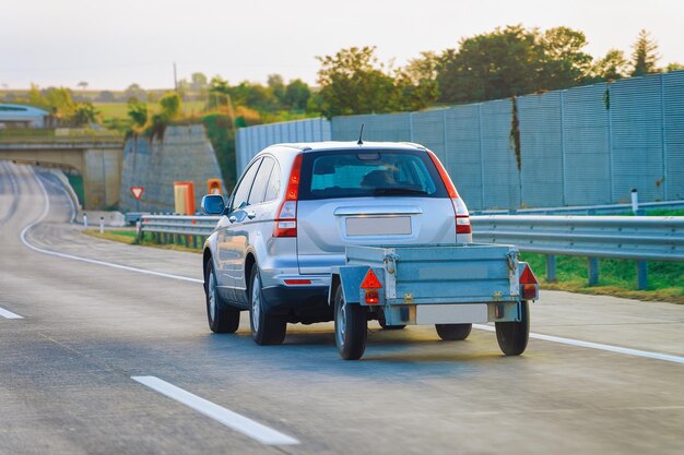 Voiture transportant une remorque sur la route goudronnée de Slovénie.