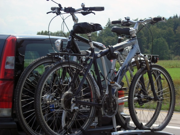 Photo la voiture transporte deux vélos sur un support spécial vacances en famille