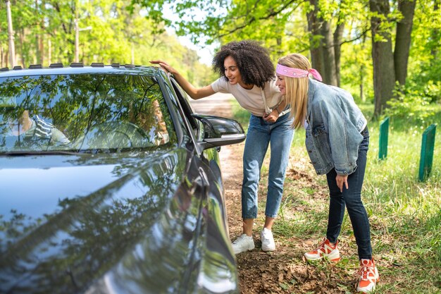 Voiture à la ville. Deux jeunes femmes parlant à l'homme dans la voiture