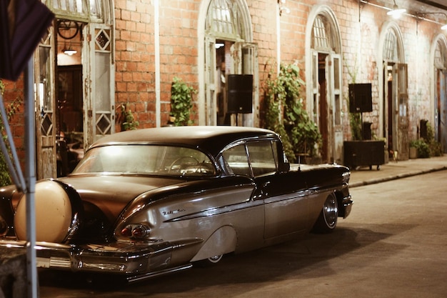 Photo une voiture vintage dans la rue la nuit.