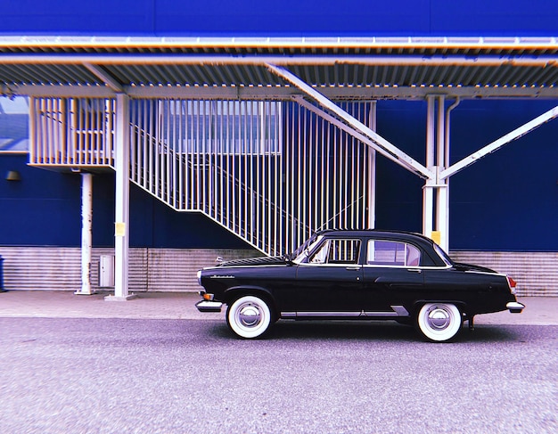 Photo une voiture vintage garée sur la route contre le bâtiment.