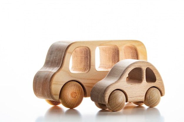 Voitures en bois pour enfants sur un mur blanc.