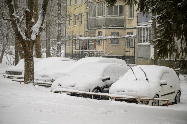 Voitures couvertes de neige coincées au parking