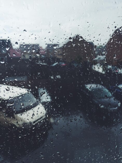 Des voitures dans la rue vues par la fenêtre pendant la saison des pluies