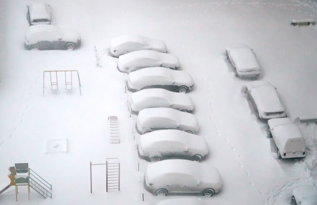 Voitures garées couvertes de neige tirées d&#39;en haut du problème urbain hivernal