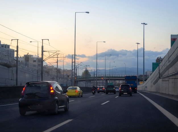 Les voitures roulent sur l'autoroute à Athènes Grèce un soir d'hiver au coucher du soleil