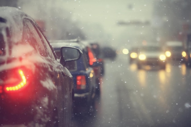 voitures sur la route d'hiver embouteillage ville / temps d'hiver sur l'autoroute de la ville, la vue depuis la voiture dans le brouillard et la route de neige