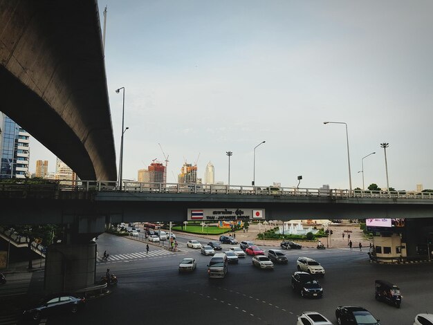 Des voitures sur la route par le pont contre le ciel en ville