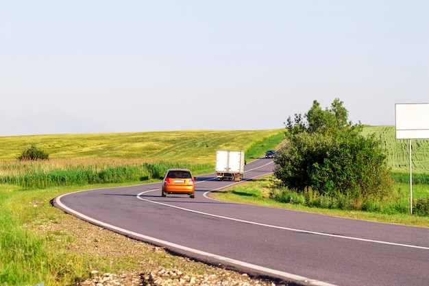 Voitures se déplaçant sur la route asphaltée en été