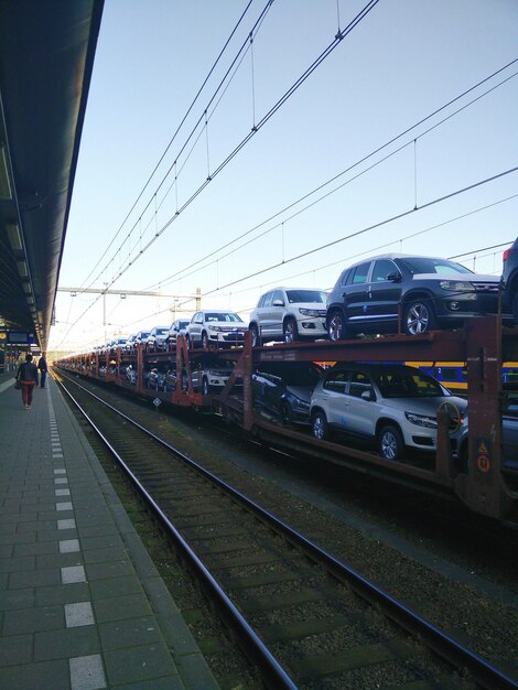 Des voitures transportées dans un train de marchandises contre un ciel dégagé