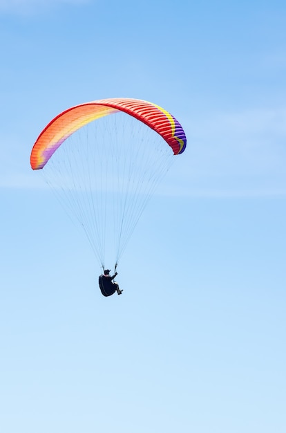Vol d'un athlète de parapente contre le ciel