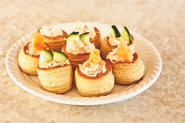 vol au vent salé fourré à la crème de fruits de mer et décoré de saumon et de concombre.