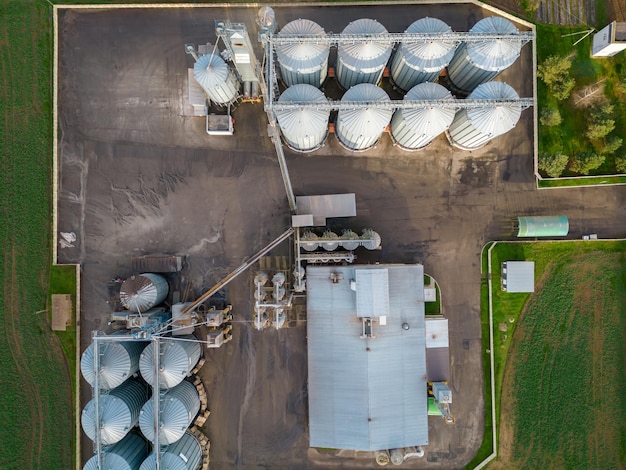 Vol de drone au-dessus d'un grand complexe agro-industriel et de barils de silos à grains à l'usine agro-industrielle pour le traitement, le séchage, le nettoyage et le stockage des produits agricoles farine céréales