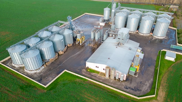 Vol de drone au-dessus d'un grand complexe agro-industriel et de barils de silos à grains à l'usine agro-industrielle pour le traitement, le séchage, le nettoyage et le stockage des produits agricoles farine céréales